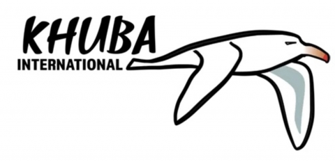 The words Khuba International are written in black next to a cartoon seagull who is flying through the air.